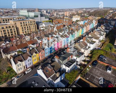 Die lebhaften, regenbogenfarbenen Häuser aus der Vogelperspektive bilden einen markanten Kontrast zu den gedämpften Tönen der umliegenden Stadtlandschaft in Brighton, Engla Stockfoto