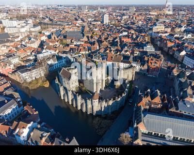 Blick aus der Vogelperspektive auf die Burg Gravensteen, eine mittelalterliche Festung inmitten einer Stadt, deren Steinmauern die umliegenden Dächer reflektieren, Gent, Flande Stockfoto