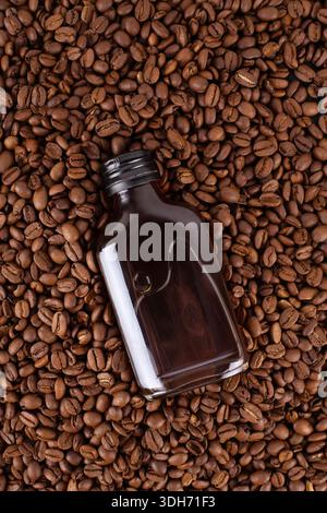 Eiskaltbrühkaffee in der Flasche Mockup auf Kaffeebohnen. In Flasche mit leerem Etikett. Kopierraum Stockfoto