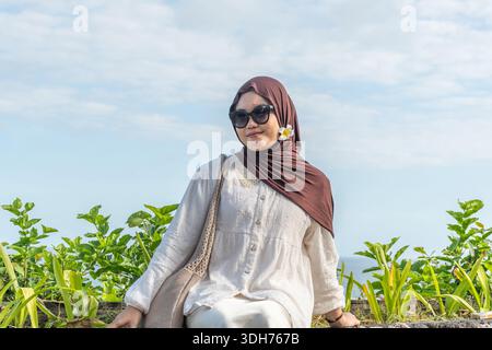 Stilvolle muslimische Frau trägt Hijab und Sonnenbrille im Freien und hält einen modernen, bescheidenen Lifestyle-Moment in einer natürlichen Umgebung fest Stockfoto