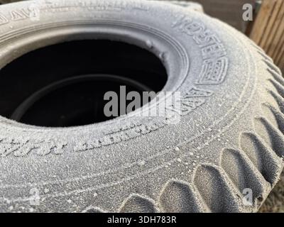 Nahaufnahme von gestapelten Autoreifen, die bei kaltem Wetter mit Frost bedeckt sind, mit Textur und Reifendetails Stockfoto