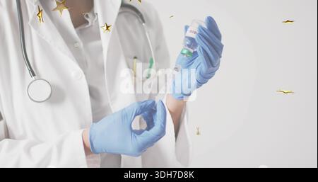 Vorbereitung der Krankenschwester, die in der Klinik in die Spritze zieht, blaue Handschuhe, Laborkittel, mit grünem Fläschchen, goldenen Sternen Stockfoto