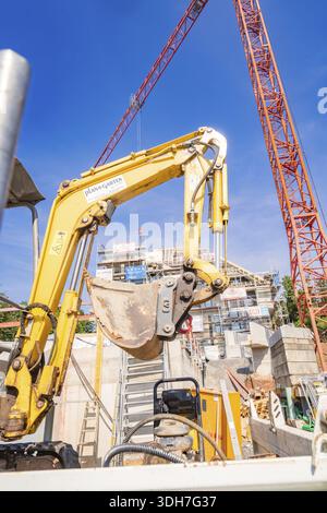 Großer gelber Bagger auf einer Baustelle umgeben von Baukränen, Zimmerei, Neubau, Stuttgart, Deutschland Stockfoto
