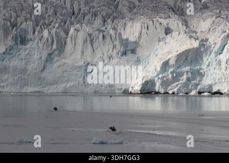 Kreuzfahrttouristen vor einer Gletscherwand auf Spitzbergen Stockfoto