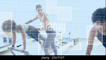 Coach, der zwei Frauen in Leggings auf Reformern bei knienden Bewegungen im Studio mit Gitter begleitet Stockfoto