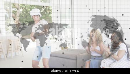Ein Mann mit VR-Headset, Shorts und Controllern im Wohnzimmer mit Kartenüberlagerung Stockfoto