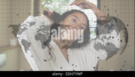 Frau kämmt Haare im Badezimmer mit Haarbürste, weißem Bademantel, Jalousien, Waschbecken, Kartenüberzug Stockfoto