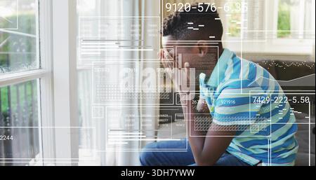 Sitzendes Kind trägt gestreiftes Polo zu Hause auf dem Sofa, das Fenster und die Veranda mit UI-Überzug beobachten Stockfoto