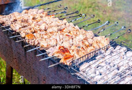 Kochen Sie traditionelle appetitliche heiße Schischebab oder Schaschlik auf Metallspießen Stockfoto