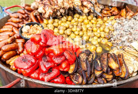 Appetitliche gebackene Paprika, Kartoffeln, Tomaten und Fleisch in einer großen Pfanne, selektiver Fokus Stockfoto