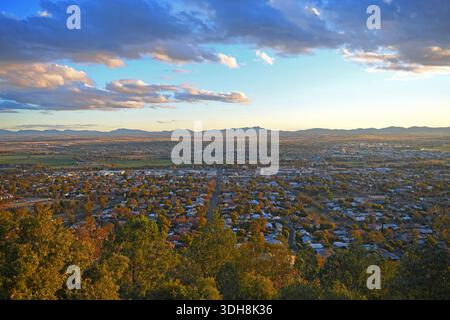 Tamworth - „die Stadt des ersten Lichts“ in Australien vom Oxley Scenic Lookout aus gesehen. Ein Blick aus der Vogelperspektive auf Tamworth Stadt zur goldenen Stunde mit Wolken am Himmel. Stockfoto