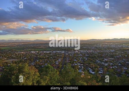 Tamworth - „die Stadt des ersten Lichts“ in Australien vom Oxley Scenic Lookout aus gesehen. Ein Blick aus der Vogelperspektive auf Tamworth Stadt zur goldenen Stunde mit Wolken am Himmel. Stockfoto