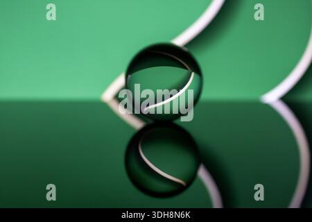 Abstrakter grüner geometrischer 3D-Hintergrund mit Kristallkugel. Echte Fotografie mit Kunsteffekten und negativem Raum. Kreatives Kopieren und Einfügen im Hintergrund Stockfoto