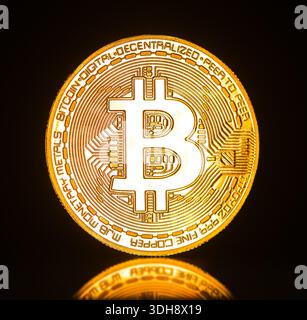 Ein goldener Bitcoin mit dem Buchstaben B drauf. Die Münze ist glänzend und hat eine reflektierende Oberfläche Stockfoto