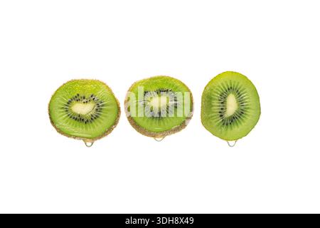 Drei Scheiben grüne Kiwis. Die mittlere Schicht wird halbiert Stockfoto