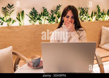 Junge Frau, die schockierende Nachrichten bekommt, überraschend Computer-Laptop-Bildschirm Stockfoto