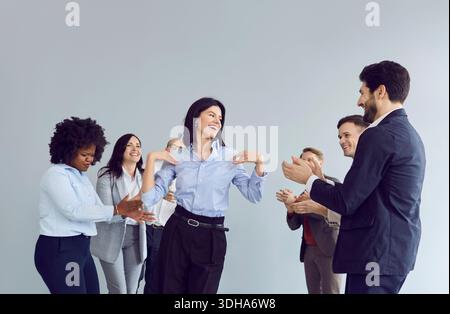 Gruppe von glücklichen Geschäftsleuten, Männer und Frauen in Anzügen, die Spaß beim Stehen im Büro haben. Stockfoto