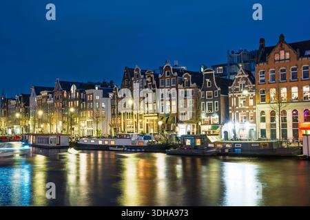 Nächtliche Kanalpracht der beleuchteten Amsterdamer Gebäude spiegeln sich in den Wasserstraßen der Niederlande wider Stockfoto