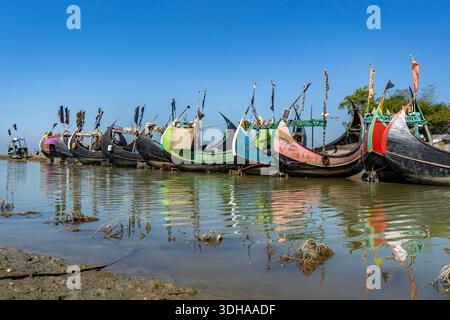 Traditionelles Mondboot (Sampan) an der Küste von Teknaf, Cox's Bazar. Buntes Holzfischboot an einem Sandstrand unter klarem blauen Himmel Stockfoto