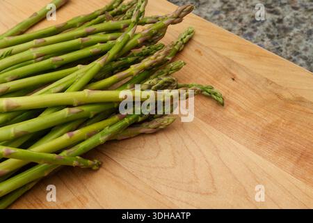 Nahaufnahme frischer Spargelspeere auf hölzernem Schneidebrett Stockfoto