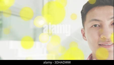 Einen asiatischen Mann mit rotem Karohemd, das rechte Gesicht im Inneren, gelbes Bokeh, Kopierraum Stockfoto