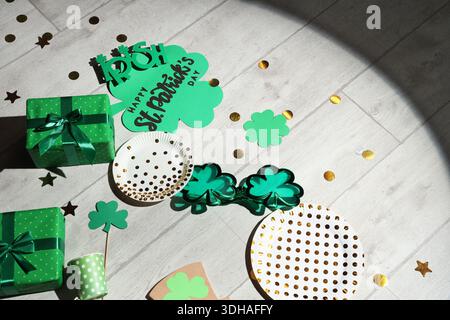 Nach der Party versammeln Sie sich mit Geschenken und Dekor für St. Patrick's Day auf Holzboden Stockfoto