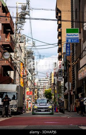 Osaka, Japan – 4. November 2025: Vertikale Aufnahme eines kleinen, individuell abgestimmten Autos, das tagsüber auf den Straßen von Osaka fährt Stockfoto