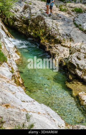 Klares türkisfarbenes Wasser fließt durch enge Kalksteinkanäle in der Mostnica-Schlucht, Triglav-Nationalpark, Slowenien. Stockfoto