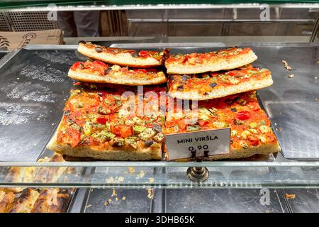 Scheiben italienischer vegetarischer Pizza mit Gemüse auf der Theke des Restaurantbuffets Stockfoto