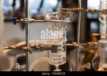 Nahaufnahme eines Cold Brew Coffee Towers aus klarem wissenschaftlichen Glas mit komplizierten Röhrchen und Tropftrichter, der für die langsame Tropfmethode verwendet wird, sorgt für einen ruhigen Schlaf Stockfoto