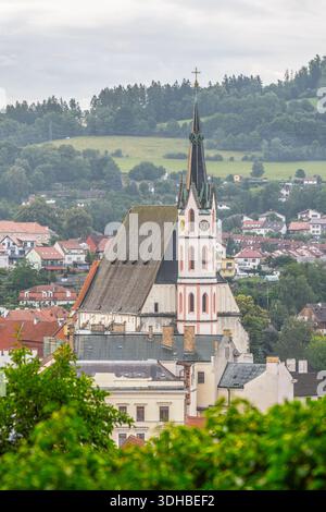 Die St.-Veit-Kirche steht hoch in Cesky Krumlov. Diese historische Kirche zieht Besucher an, die die Stadt erkunden. Die Szene fängt das Wesen eines Sommertages in Tschechien ein. Stockfoto