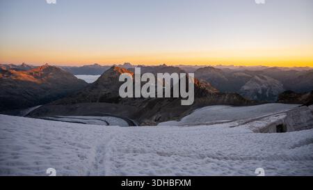 Erleben Sie die atemberaubende Schönheit des Pers-Gletschers bei Sonnenaufgang in der Bernina-Gebirgskette der Schweizer Alpen. Schneebedeckte Gipfel und sanftes Morgenlicht schaffen eine ruhige alpine Landschaft. Stockfoto