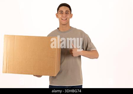 Junger Mann, der einen großen Karton zum Umziehen hält Stockfoto