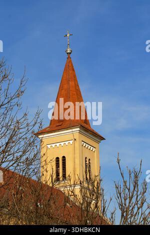 Der hoch aufragende Kirchturm in Veszprém erhebt sich vor einem leuchtend blauen Himmel. Stockfoto