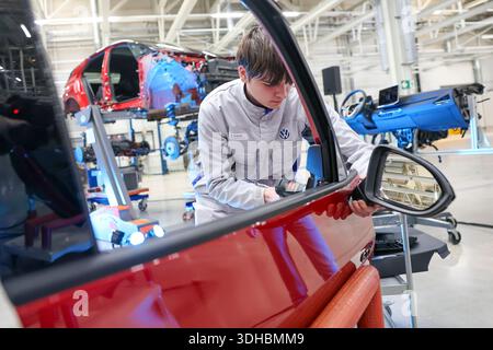 Zwickau, Deutschland. Januar 2026. Bei der Präsentation der Recyclingstrategie im VW-Werk nimmt ein VW-Mitarbeiter den Außenspiegel aus einem demontierten VW ID.3. Ab 2030 plant der Automobilhersteller Volkswagen, am Standort Zwickau jährlich bis zu 15.000 Fahrzeuge zu demontieren und zu überholen. Dazu wird Volkswagen Berichten zufolge bis zu 90 Millionen Euro investieren und 1.000 Arbeitsplätze sichern. Das Land Sachsen finanziert das Projekt mit rund 10,8 Millionen Euro. Quelle: Jan Woitas/dpa/Alamy Live News Stockfoto