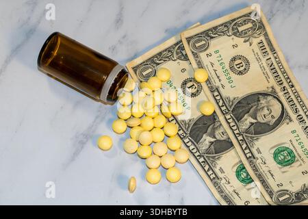 Gelbe Tabletten, die aus der braunen Flasche auf Dollarscheine verschüttet werden Stockfoto
