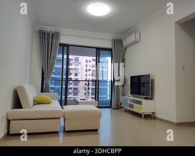 Modernes Wohnzimmer mit Sofa, TV-Einheit und Balkon Stockfoto