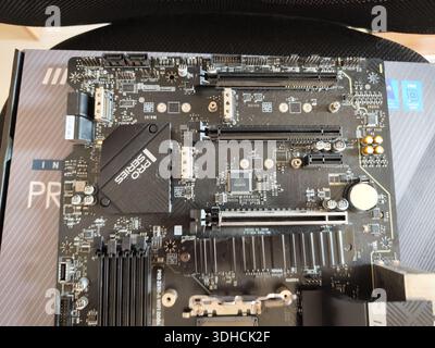 Ansicht von oben nach unten eines PC-Mainboards mit CPU-Sockel, RAM-Steckplätzen und Chipsatz-Kühlkörper Stockfoto