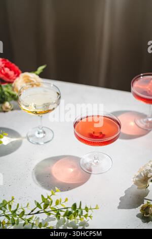 Sekt- oder Sektgläser auf weißem Hintergrund mit scharfen Schatten. Modernes, stilvolles Farbkonzept Stockfoto
