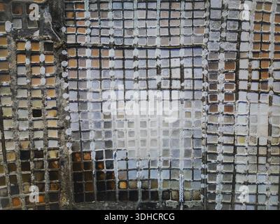 Aus der Vogelperspektive einer alten Wand, die mit Mosaikfliesen in verschiedenen Farben, Texturen und Schattierungen dekoriert ist, Daghmar, Oman Stockfoto