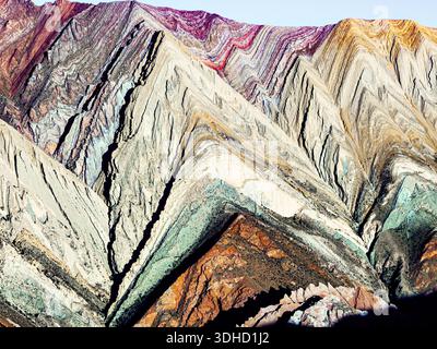 Blick aus der Vogelperspektive auf die majestätische Bergkette Serranía de Hornocal mit lebhaften Ocker-, Türkis- und Karmesintönen im dramatischen, gefalteten Felsen Stockfoto