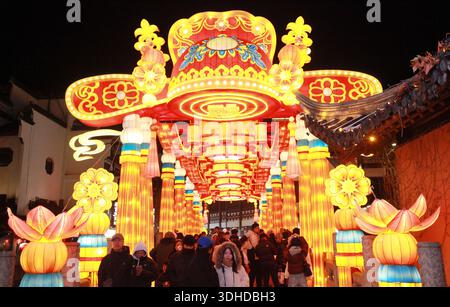 Nanjing, chinesische Provinz Jiangsu. Januar 2026. Touristen sehen die Lichtdekorationen, die während des 40. Qinhuai Laternenfestes in Nanjing, Provinz Jiangsu im Osten Chinas, am 21. Januar 2026 im malerischen Bereich des Konfuzius-Tempels ausgestellt wurden. Die Lichteremonie des Festivals fand am Mittwoch im Bailuzhou Park statt. Das Festival kann in mehreren Ausstellungsbereichen in der Nähe des Qinhuai Flusses in der Stadt Nanjing besucht werden. Quelle: Liu Jianhua/Xinhua/Alamy Live News Stockfoto