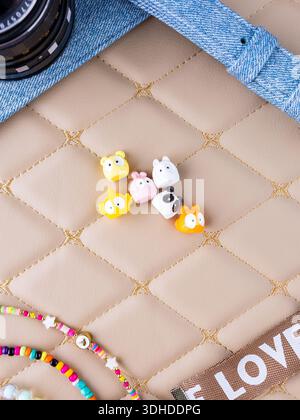 Eine Nahaufnahme eines Sets farbenfroher, entzückender Tierfiguren im Kawaii-Stil, die auf einer Lederoberfläche platziert sind Stockfoto