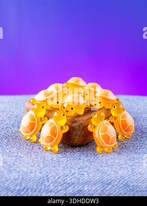 Eine Nahaufnahme einer Reihe von orangen, verspielten Schildkröten-Innenfiguren, die auf einer Holzbühne angeordnet sind Stockfoto