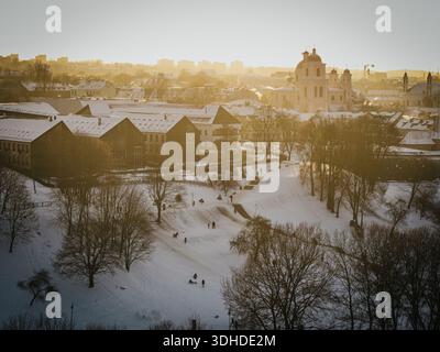 Aus der Vogelperspektive auf die schneebedeckte Landschaft mit den berühmten Kuppeln von St. Peter und St. Pauls Kirche schimmern in der Ferne, Vilnius, Litauen. Stockfoto