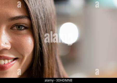 Afroamerikanerin lächelt und sieht die Kamera im Studio mit Nasenstiel, Haaren, Bokeh Stockfoto