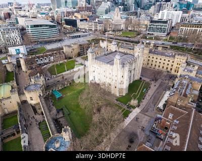 Drohnenfoto des White Tower im Tower of London mit der Skyline der Stadt London an einem klaren Tag im Hintergrund. Stockfoto