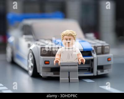 Tambow, Russische Föderation – 21. August 2025 Lego Brian O'Conner Minifigur vor seinem Nissan Skyline GT-R (R34) Auto in der Stadtstraße. 2 F Stockfoto