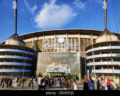 Außenansicht des Etihad Stadions mit Fans, die sich an einem sonnigen Tag draußen versammeln Stockfoto