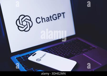 Izmir, Türkei - 21. Januar 2026: Foto eines Laptops mit ChatGPT AI Logo auf weißem Hintergrund, modernes Smartphone auf der Tastatur ebenfalls abgelegt Stockfoto